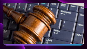 A courtroom gavel on top of a computer keyboard.