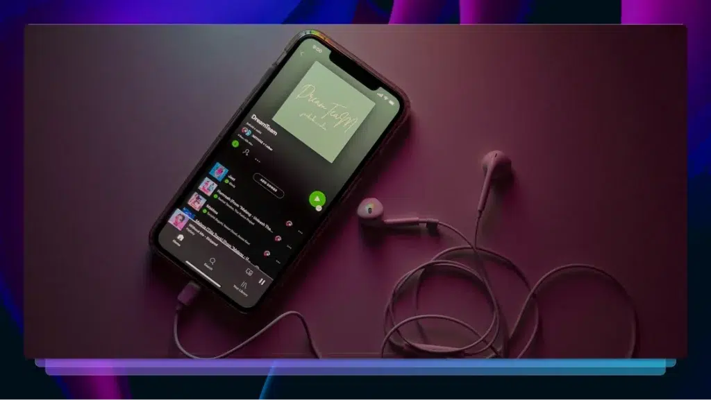 An iPhone showing a podcast on Spotify with earbuds plugged in.