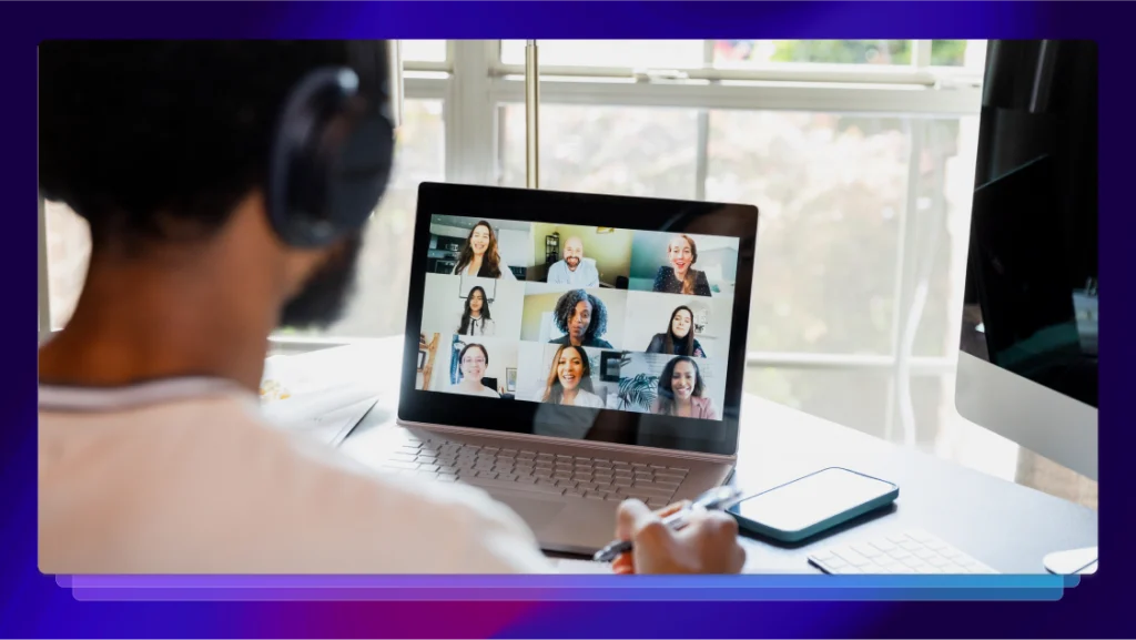 A person wearing headphones in front of a laptop while in a Zoom meeting.