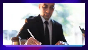 Man in a suite signing a document with a white pen